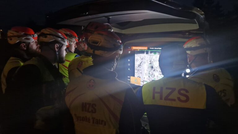 záchranári HZS sledujúci zábery z dronu