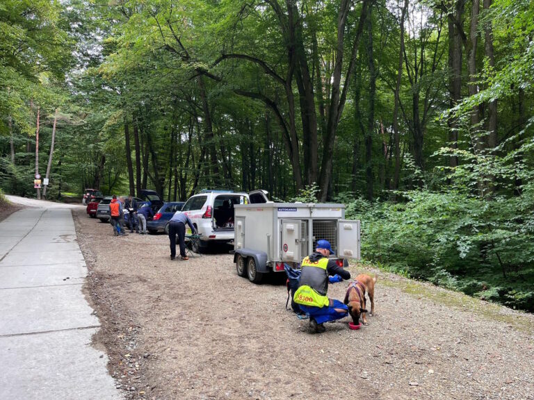 kynológ so služobným psom pri záchrannom vozidle HZS