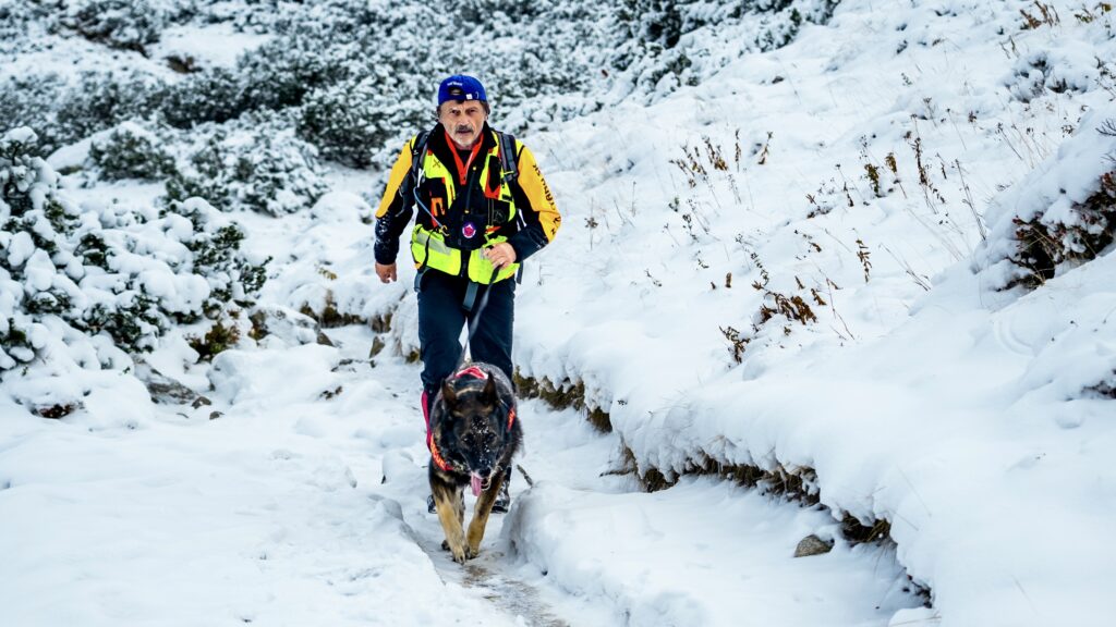 Kynologické preteky HZS - záchranár HZS na lyžiach so svojim psom v zasneženom teréne 