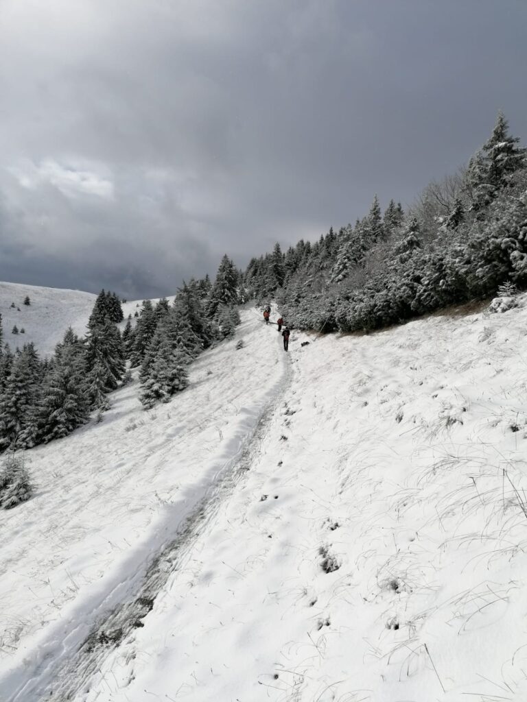 zasnežený hrebeň Veľkej Fatry, záchranári HZS pri osádzaní zimného tyčového značenia