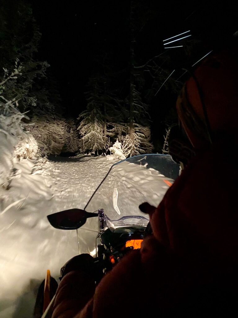 Jazda skútrom v noci zasneženou krajinou