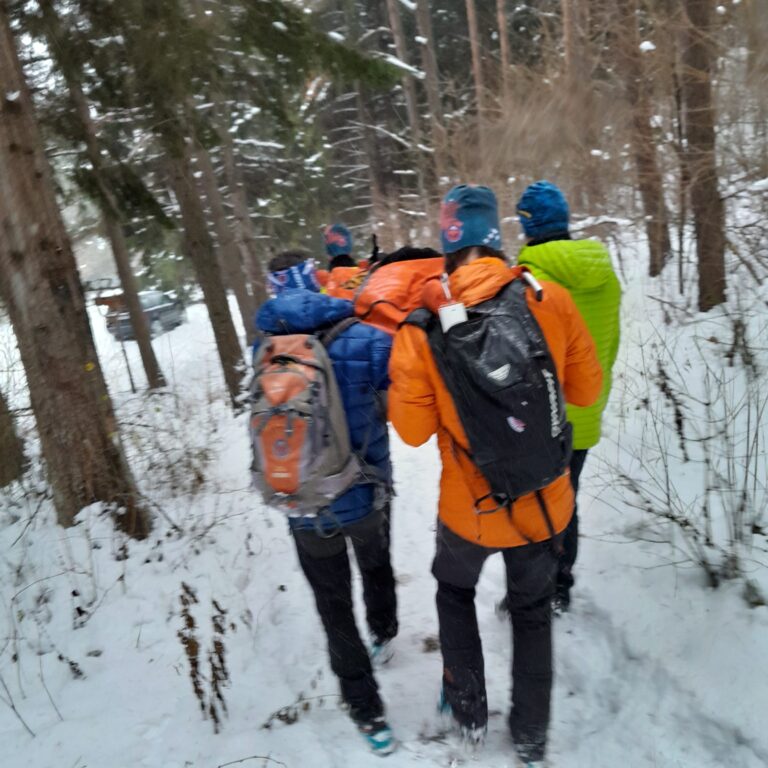 transport pacienta na nosidlách záchranármi HZS cez zasnežený les