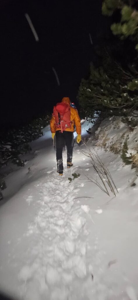 Horský záchranár postupuje zasneženým turistickým chodníkom