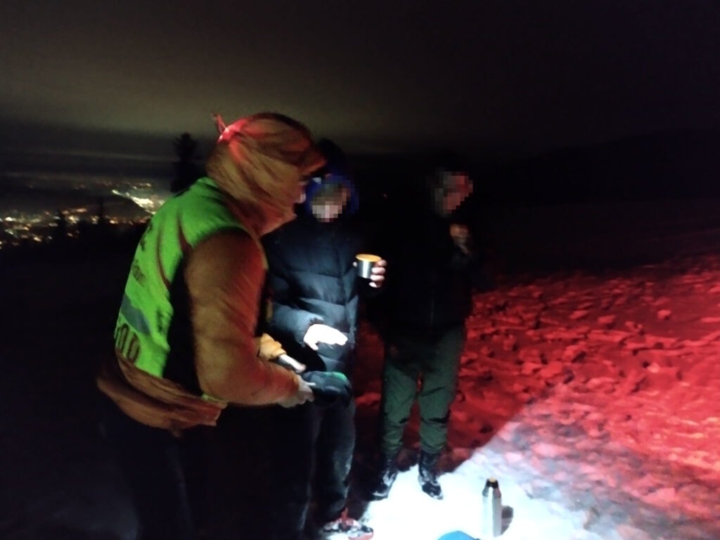 Dvaja vyčerpaní turisti so záchranárom 