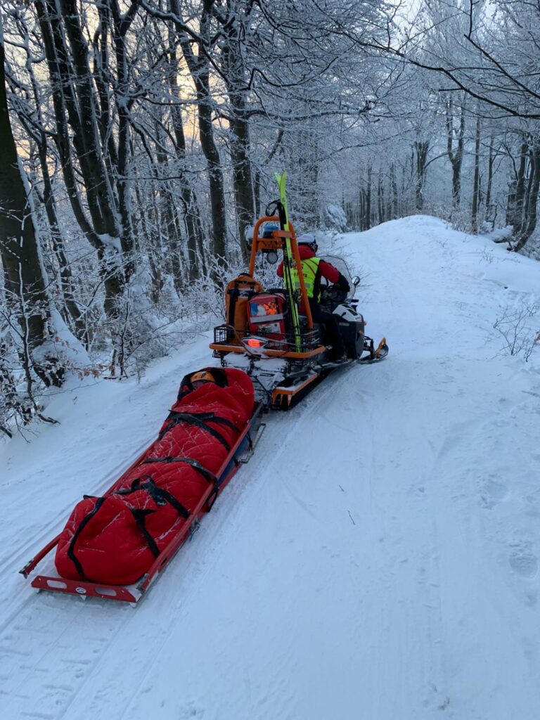 transport skialpinistky v saniach za skútrom