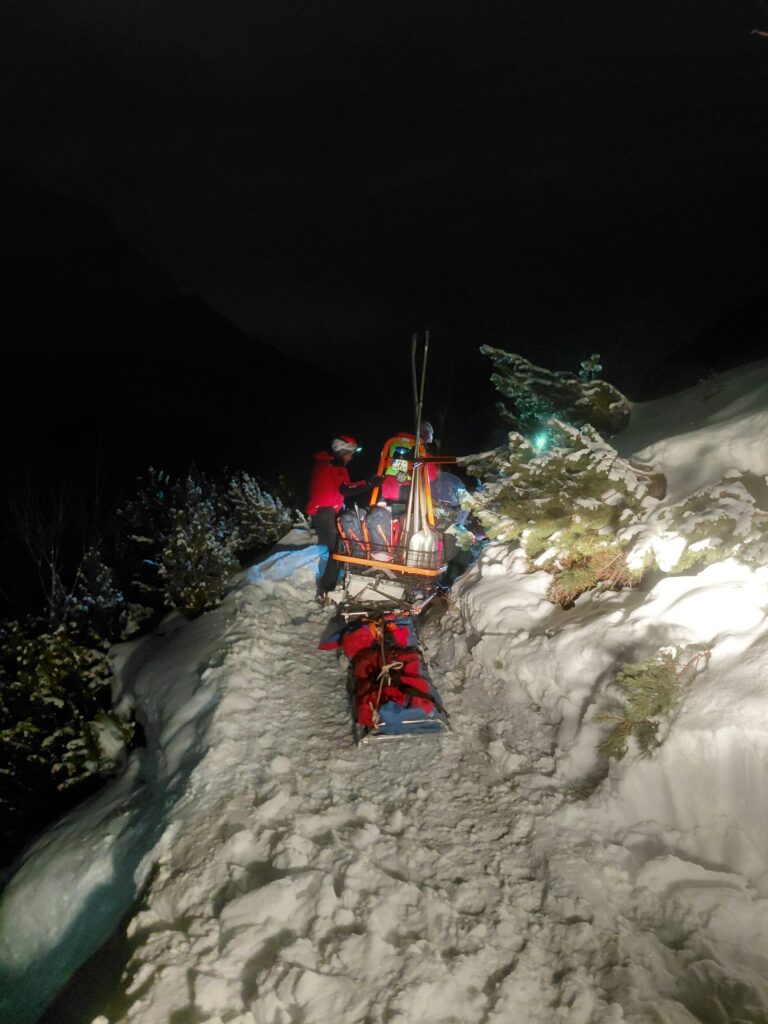 Záchranári HZS smerujú na snežnom skútri so saňami pripevnenými za skútrom do Veľkej Studenej doliny za zraneným skialpinistom