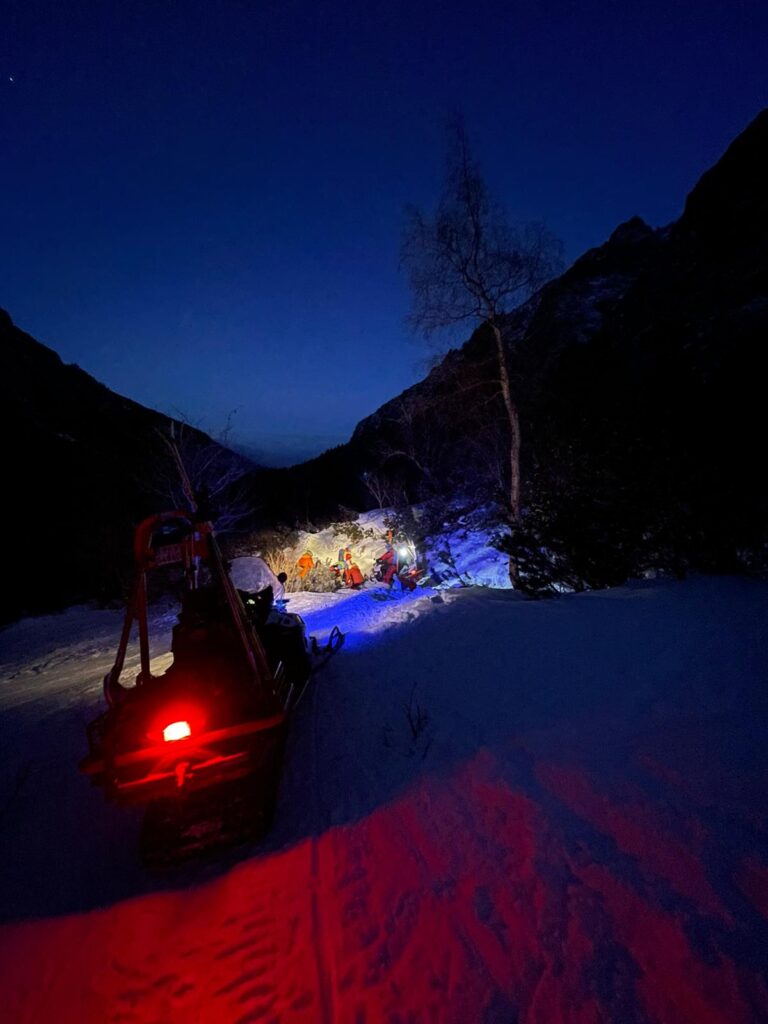 snežný skúter vo večernej zasneženej doline 
