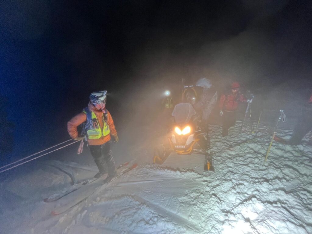 záchranári so snežným skútrom postupujú s uviaznutými turistami