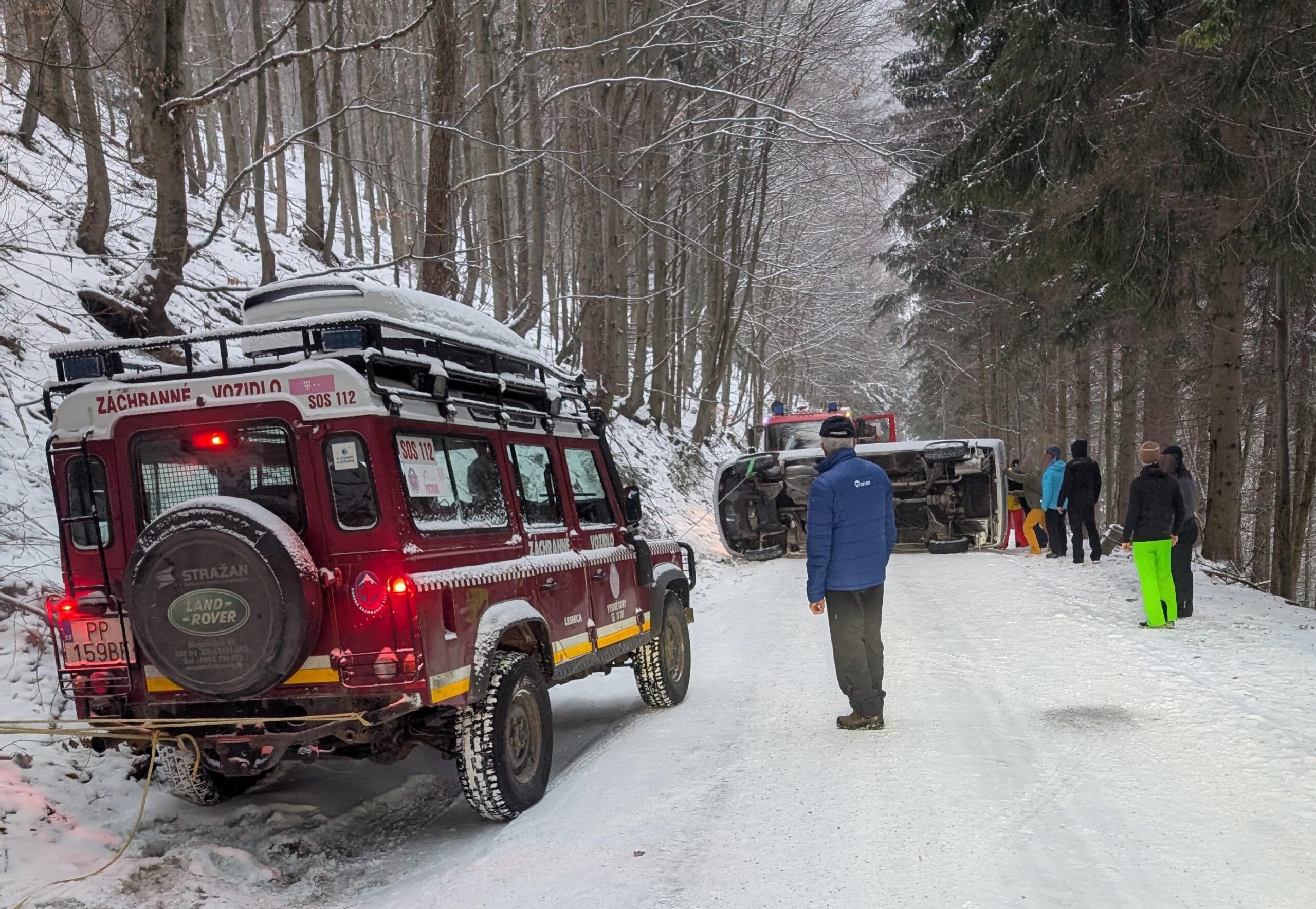 vozidlo HZS na prístupovej komunikácii k lyžiarskemu stredisku na Martinských holiach s havarovaným osobným vozidlom