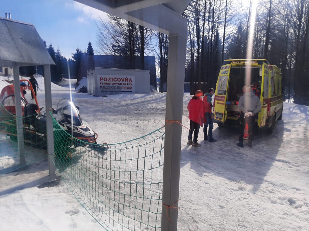 snežný skúter HZS a RZP pri bežeckom štadióne na Skalke so záchranárom HZS a záchranárom ZZS - preberanie pacientky