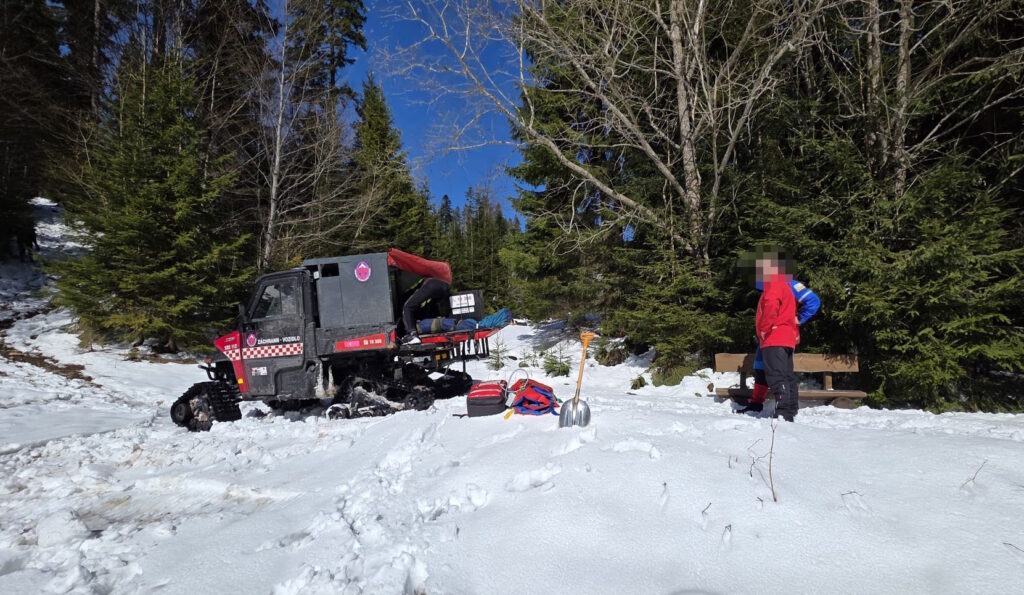 Horskí záchranár pri nakladaní pacienta do pásovej štvorkolky