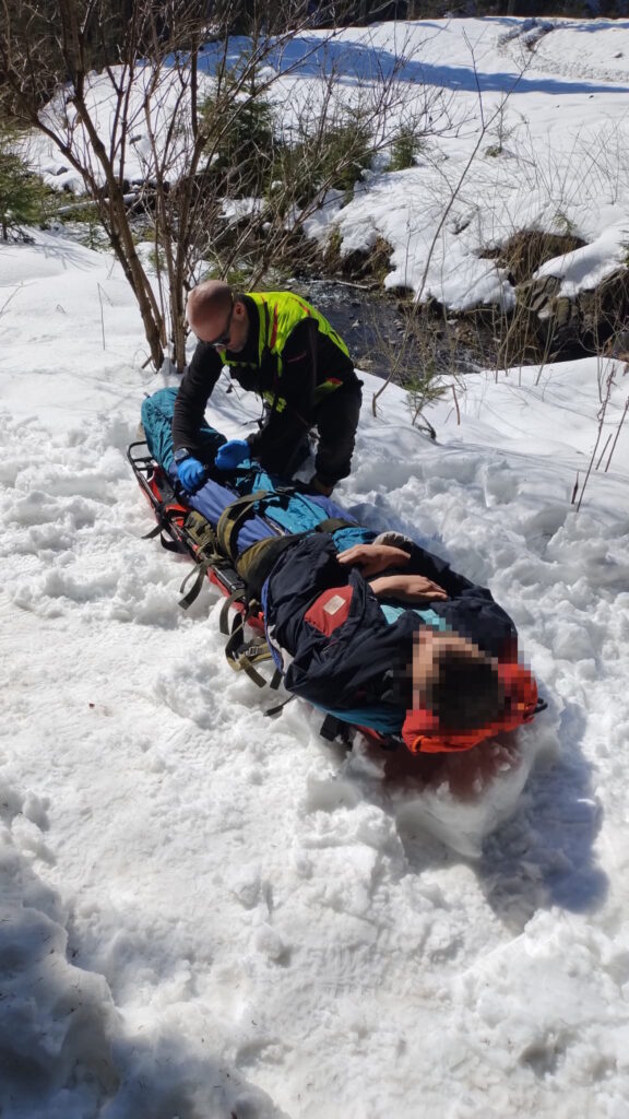 Horskí záchranár pri nabalenom pacientovi na nosidlách UT