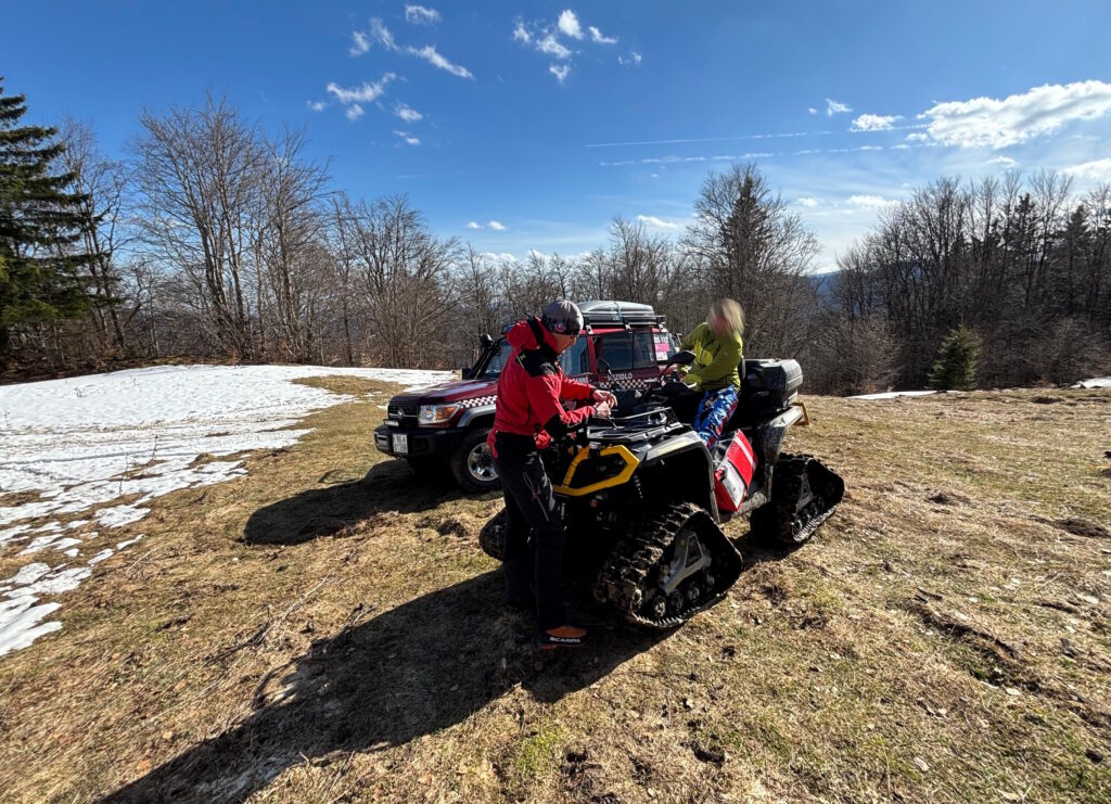 záchranár HZS s pacientkou usadenou na pásovej štvorkolke
