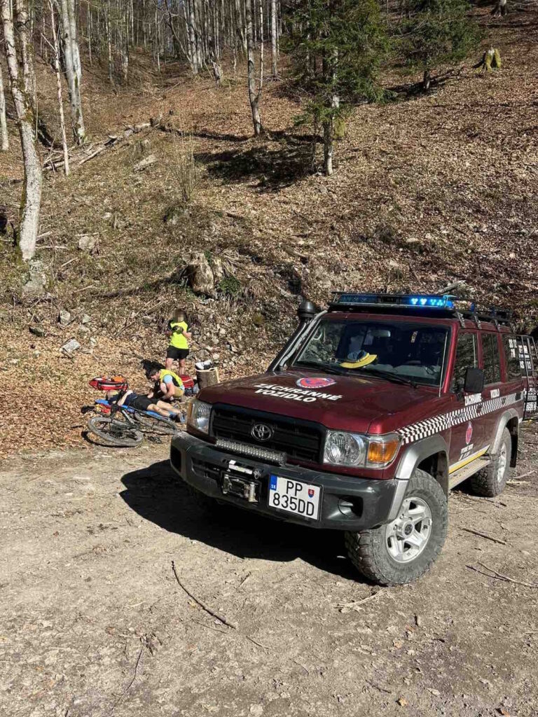 záchranári HZS vedľa terénneho vozidla ošetrujú zraneného cyklistu