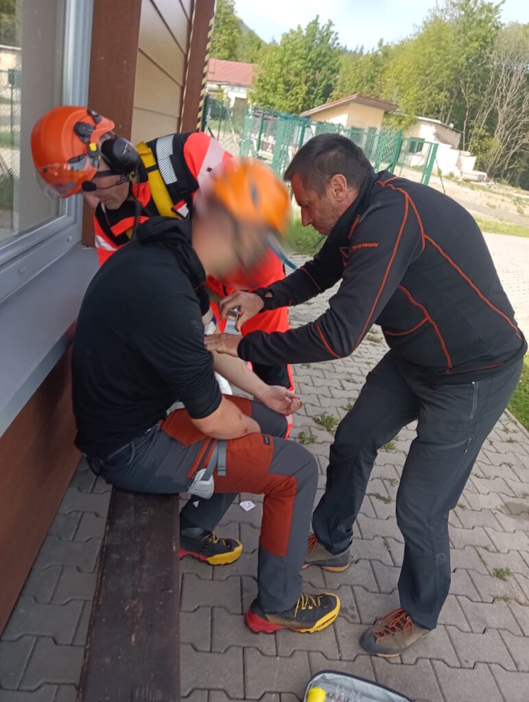lekár VZZS so záchranárom HZS ošetrujú pacienta na heliporte v Starom Smokovci