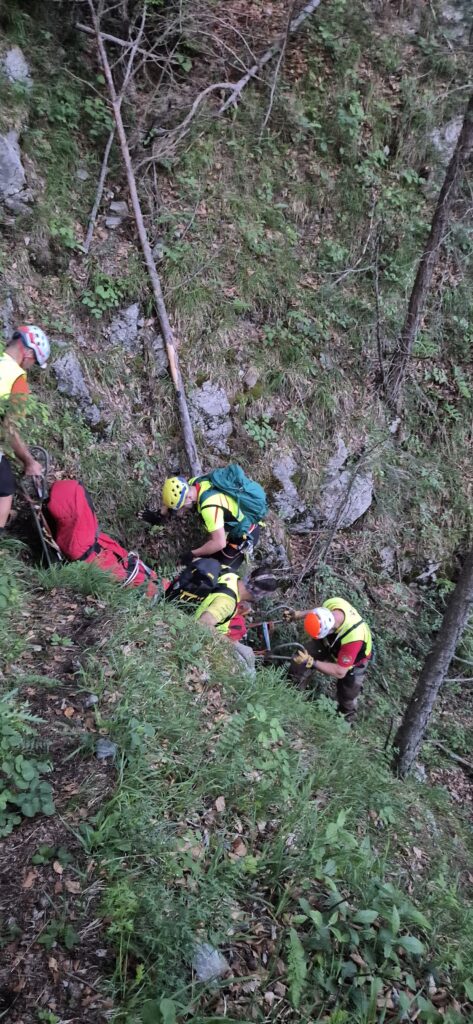 záchranári HZS pri transporte pacienta pomocou lanovej techniky v strmom teréne