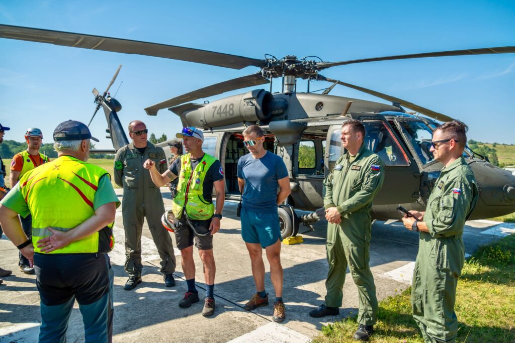 účastníci kynologického cvičenia dostávajú inštrukcie pred cvičením s nasadením vrtuľníka Blackhawk