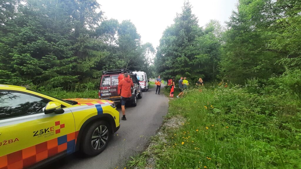 automobil lekára posádky RV, sanitné vozidlo a záchranné vozidlo HZS na asfaltovej ceste, záchranári smerujú k pacientovi