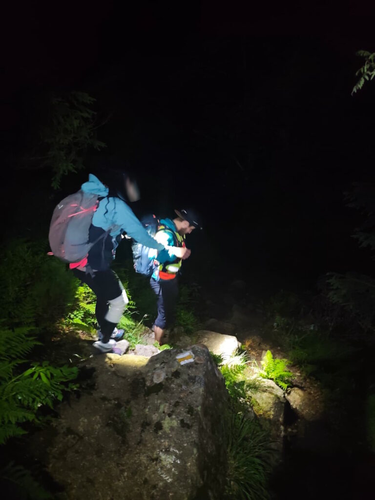 záchranár HZS zostupuje v noci s turistkou z hrebeňa Západných Tatier