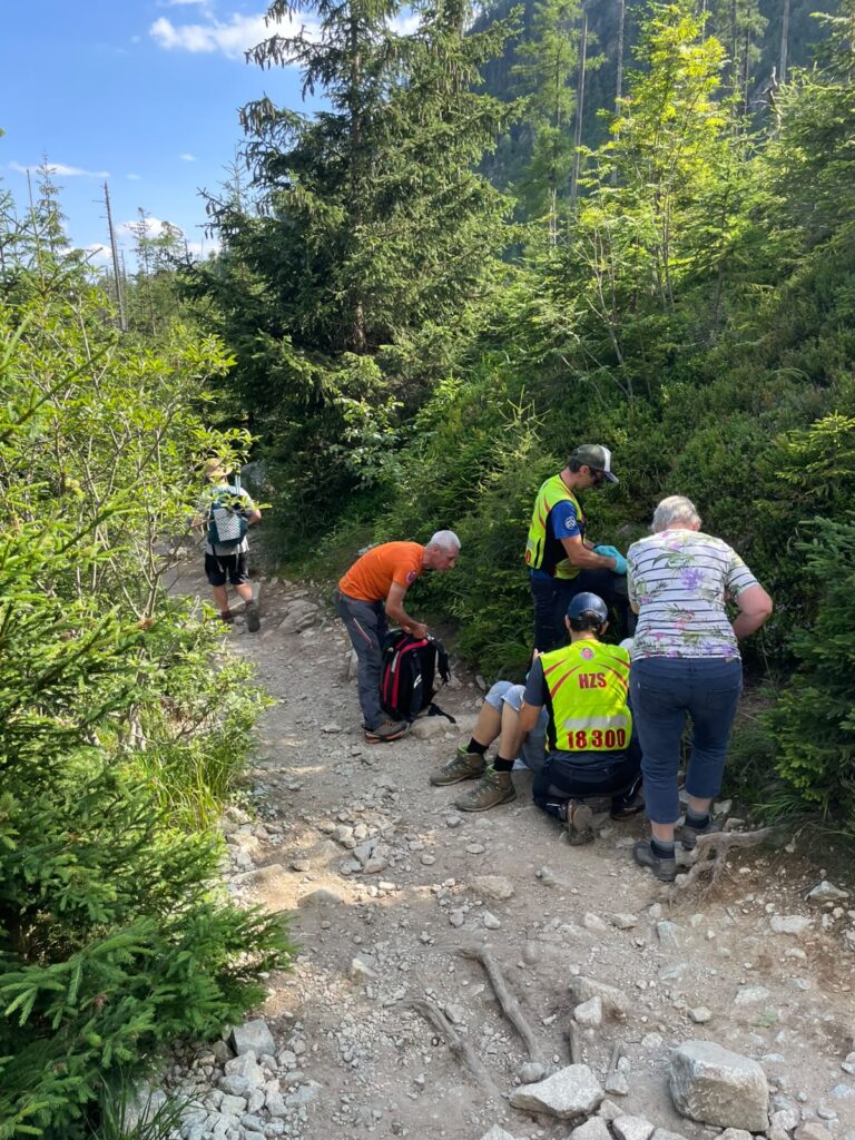 Horskí záchranári pri ošetrovaní turistu s tržnou ranou na hlave