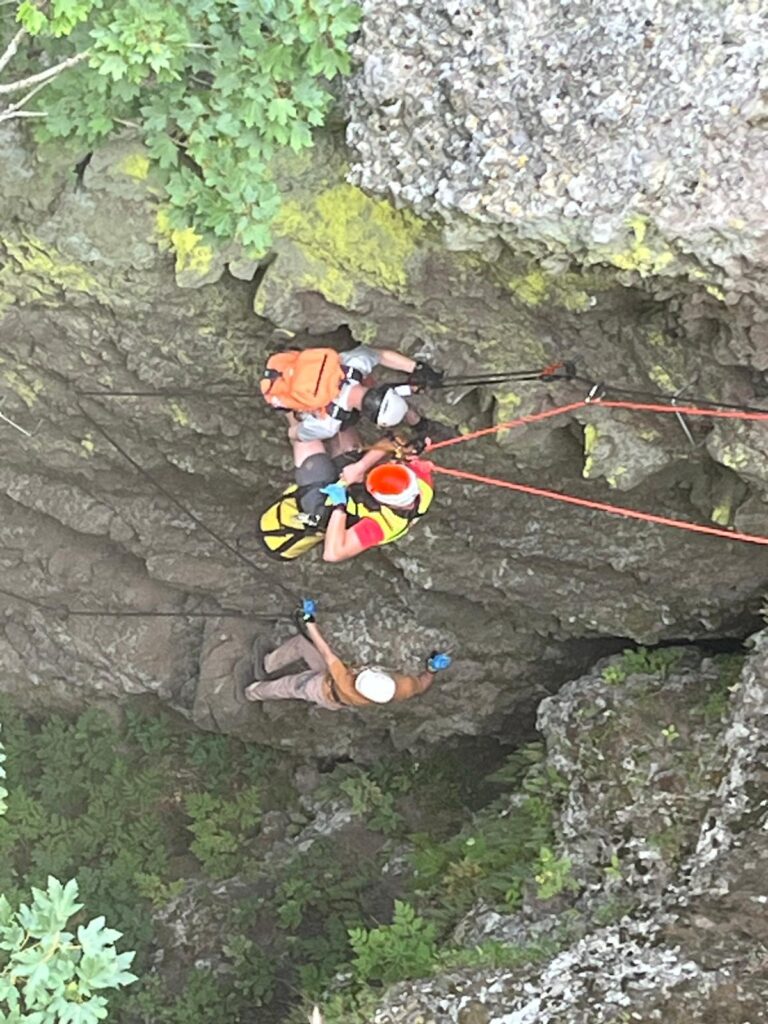záchranár HZS pripravuje zraneného lezca vo ferratovej ceste na spust pod stenu