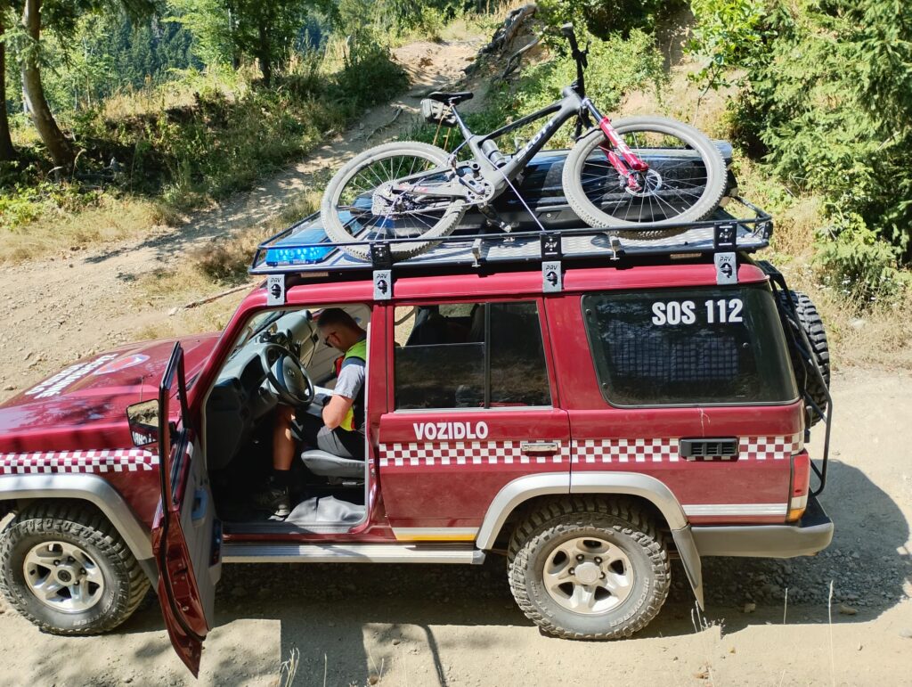 záchranár HZS v terénnom vozidle HZS na hodinovke, na streche bicykel pacienta 