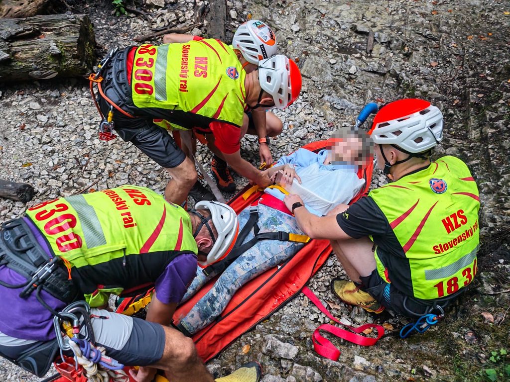 Horskí záchranári pri ošetrovaní pacientky a príprave na jej transport nosidlami KONG