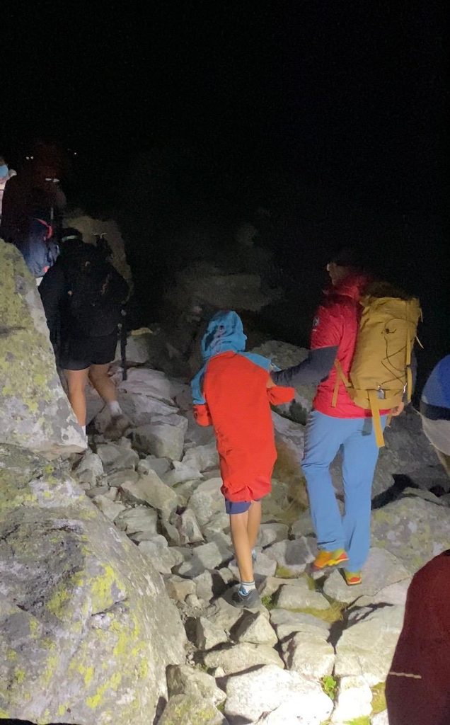 zateplený mladý turista zostupujúci za sprievodu záchranára HZS po tme Veľkou Studenou dolinou