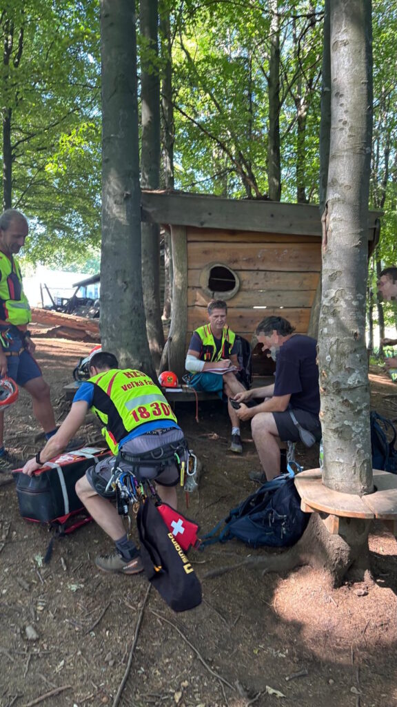 Sediaci turista po vyprostení v sprievode záchranárov